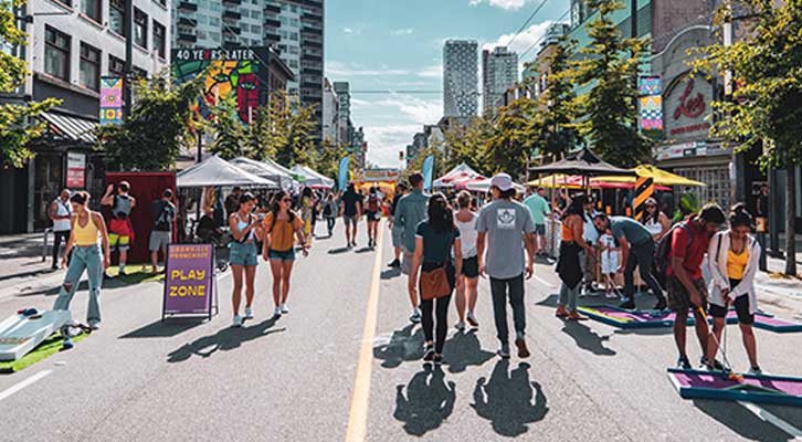 People walking, playing games, and visiting booths on Granville Street