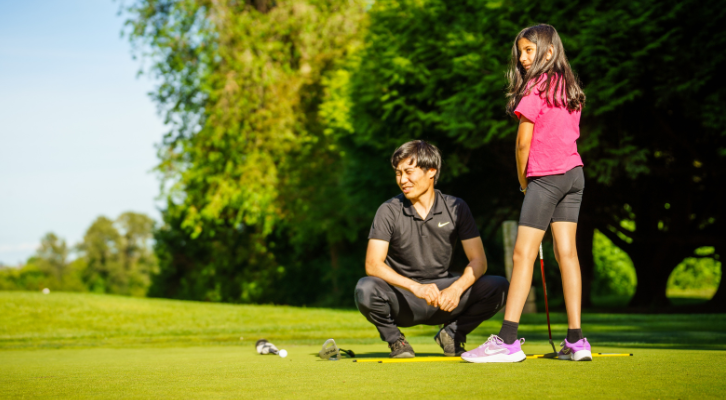 Child golfing with an adult