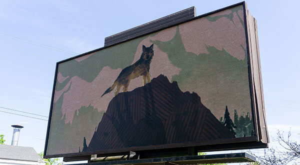 Artist Ann Siddall's artwork "Mahihkan", a wolf standing on a mountain, on a billboard