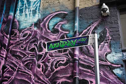 Ashtrey Alley assign with graffiti in the background