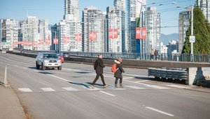 two pedestrians using a crosswalk on Granville Bridge