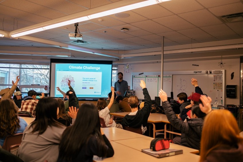 Classroom featuring a group of students with raised hands at the Cool It! Climate Leadership Training in the City of Vancouver