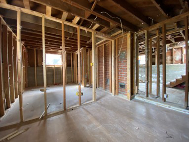 Deconstruction process showing a building taken apart carefully so wood and materials can stay intact and be reused.