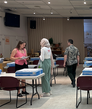 People picking up chapter 1 boxes in a classroom setting.