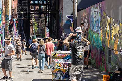 Graffiti Wall: People looking at people painting on building walls