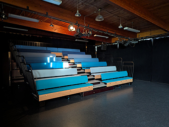 Interior of the Moberly Arts and Cultural Centre theatre with tiered seating and stage lighting.