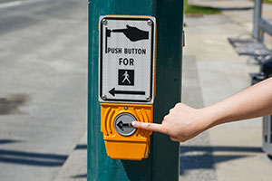 Hand pushing pedestrian signal button
