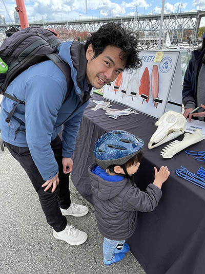 Adult and child looking at some items on a table 