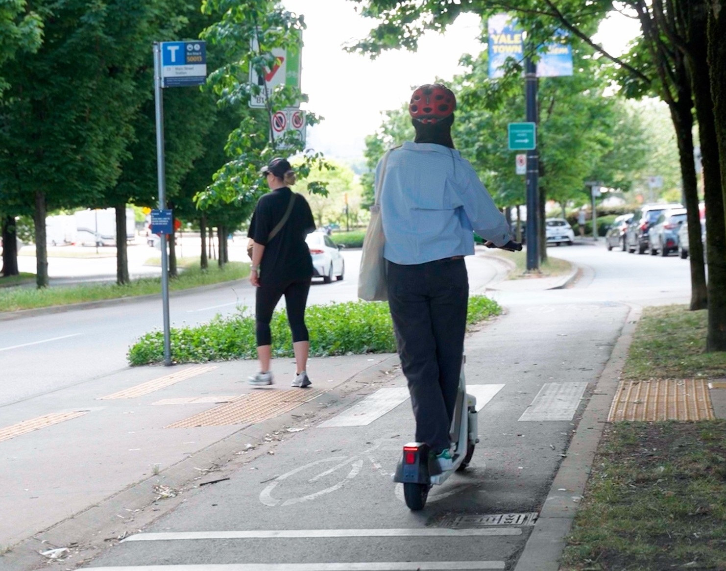 A person riding an e-scooter on a bike path