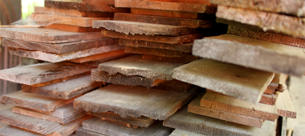 Close-up of reclaimed lumber stacked in layers.