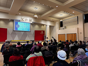 Audience watching a presentation in a community hall.