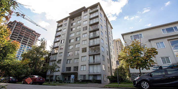 11-storey apartment tower from the street with parked cars