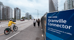 A person riding a bike on a path by a sign that says Granville Connector