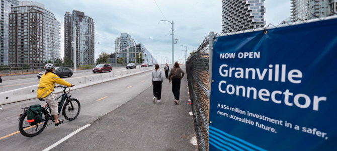 A person riding a bike on a path by a sign that says Granville Connector