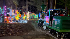 Bright Nights train on the tracks passing by Christmas theme light decorations 