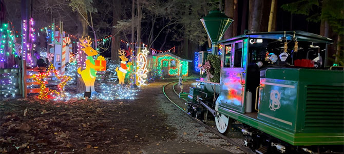 Bright Nights train on the tracks passing by Christmas theme light decorations 