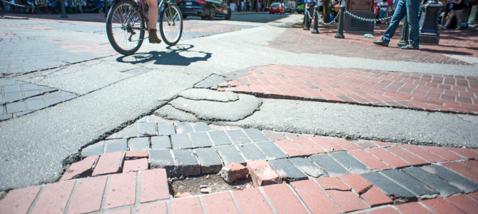 Broken pavers in Gastown featuring a cyclist biking by