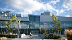 Vancouver's Creekside Community Centre with a cyclist passing by