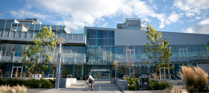 Vancouver's Creekside Community Centre with a cyclist passing by