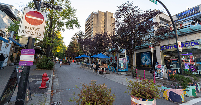 Bute-Robson Plaza on Bute St featuring a car-free street with picnic tables with blue garden umbrellas 