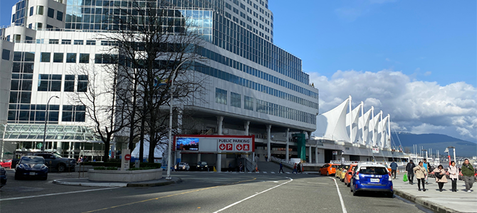 Canada Place and street with pedestrians, cars, and mountains in the background. Canada Place and street with pedestrians, cars, and mountains in the background.