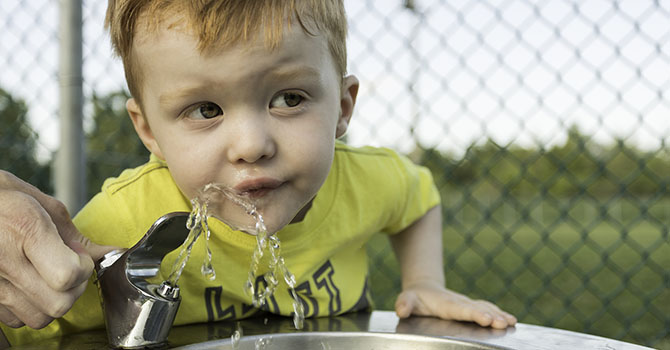 Child drinking from water fountain Child drinking from water fountain