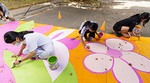 Children painting a colourful ground mural with flowers