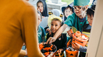 Children in Halloween costumes collect candy in pumpkin-shaped buckets while trick-or-treating
