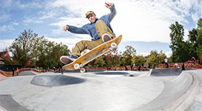 A skateboarder mid-air performing a trick at an outdoor skatepark.