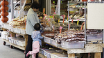 Adult and child shopping at a Chinatown herbal shop