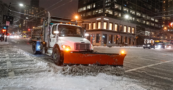 Snow plow plowing an intersection