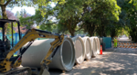 Construction being done on a road with giant concrete pipes