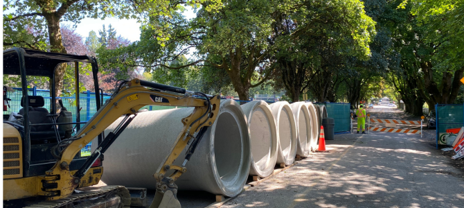 Construction being done on a road with giant concrete pipes