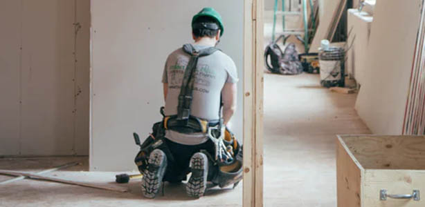 Construction worker kneeling on floor