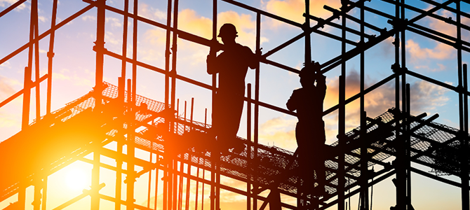 Construction workers on a scaffold at sunrise