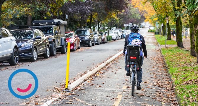 Person cycling with a child seat along a the Comox bike lane in the fall.