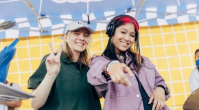 Two people DJ in a tent outdoors