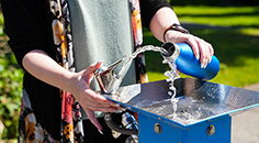 Person filling up their water bottle at the water fountain