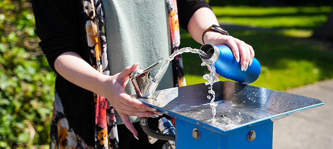 Person filling up their water bottle at the water fountain