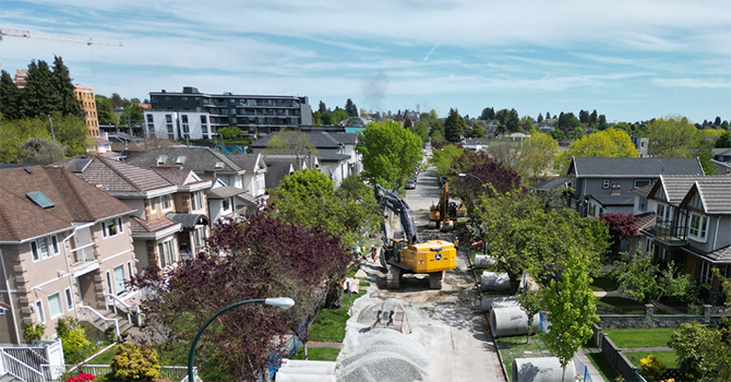 Construction crews and equipment working on East 35th Avenue to upgrade sewer infrastructure in a residential neighbourhood. Construction crews and equipment working on East 35th Avenue to upgrade sewer infrastructure in a residential neighbourhood.