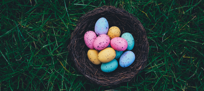 Basket on grass with multiple painted eggs