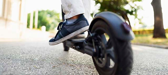 A person rides an electric scooter on a street