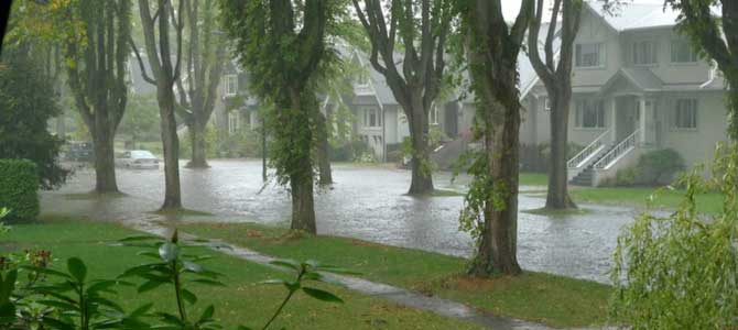 Heavy rain and flooding of a street with houses 