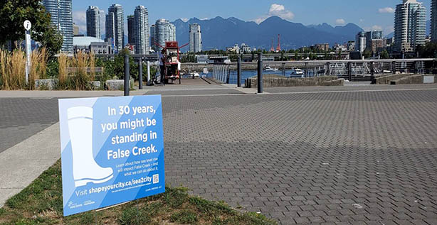 Sign in grass near seawall in Olympic Village