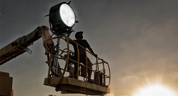 Person with film light on cherry picker