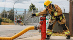 A firefighter unscrews a fire hydrant