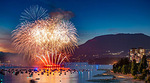 Fireworks exploding into red and white colours over Vancouver's English Bay beach during the Celebration of Light festival