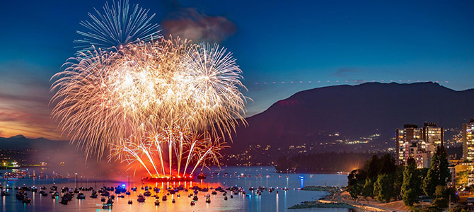 Fireworks exploding into red and white colours over Vancouver's English Bay beach during the Celebration of Light festival Fireworks exploding into red and white colours over Vancouver's English Bay beach during the Celebration of Light festival