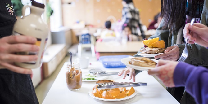 Food on a table with people gathered around