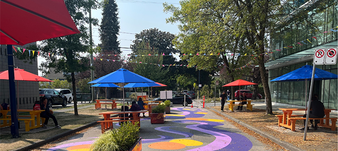 A vibrant public plaza with seating and umbrellas